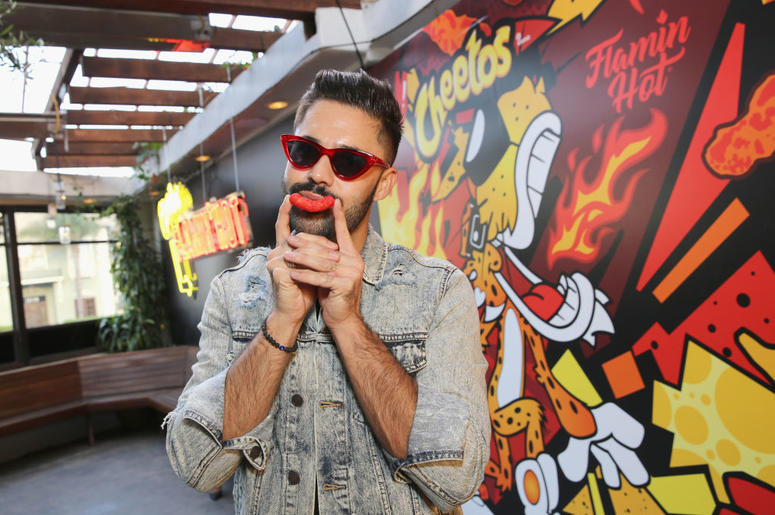 (Rachel Murray/ Getty Images) Guy uses a flamin' hot Cheeto puff as a mustache