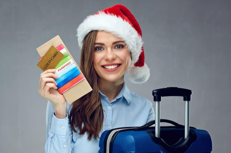Smiling woman traveler wearing christmas hat holding passport Smiling woman traveler wearing christmas hat holding passport