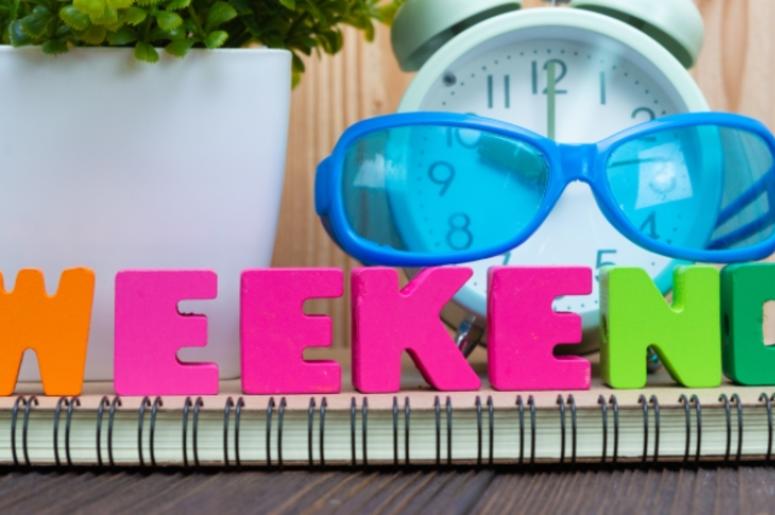 WEEKEND letters text and notebook paper, alarm clock and little WEEKEND letters text and notebook paper, alarm clock and little