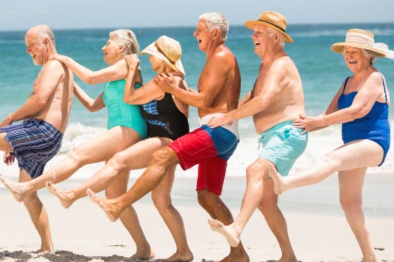 Seniors dancing in a row at the beach Seniors dancing in a row at the beach