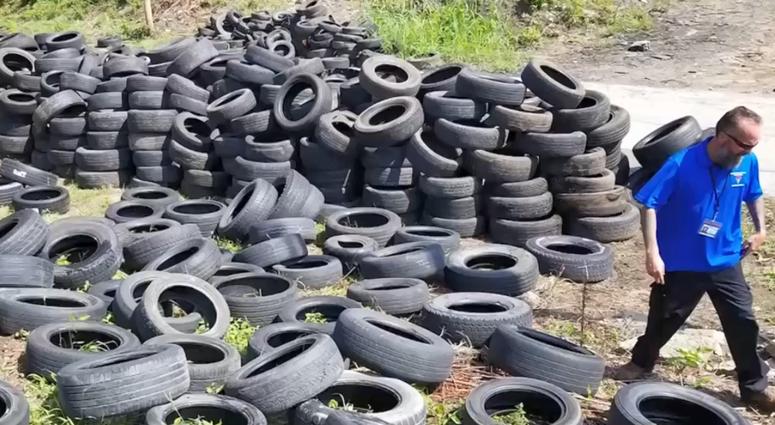 Kansas City illegal dumping investigator walks through a lot containing thousands of tires
