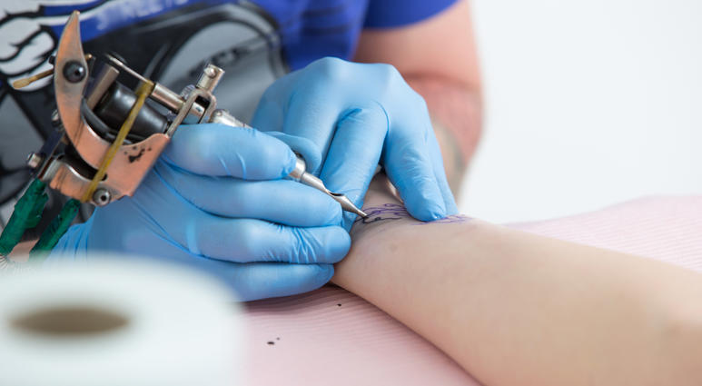 Person giving a tatoo on another persons arm