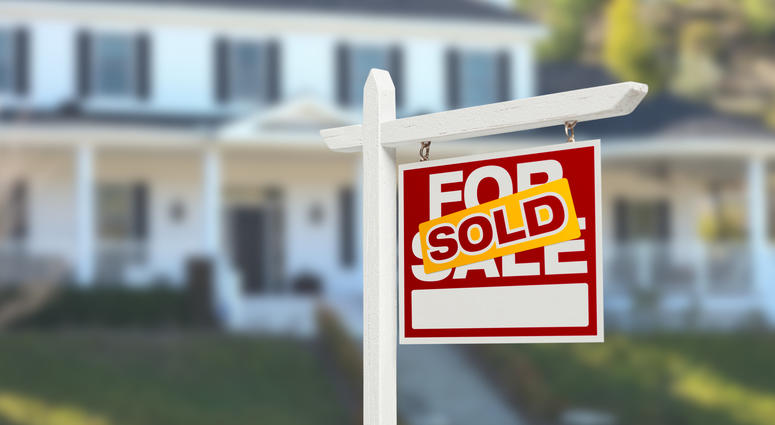 Home with sold sign in front of it