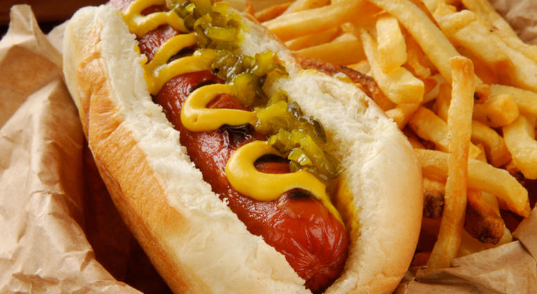 hotdog Very closeup shot of a hot dog with mustard, relish and fries - shallow depth of field, focus on hot dog