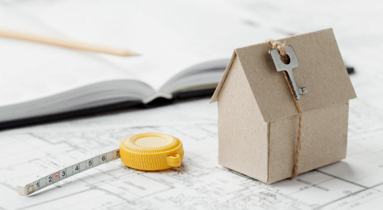 construction, home Model of cardboard house with key and tape measure on blueprint. Home building, architectural and construction design concept