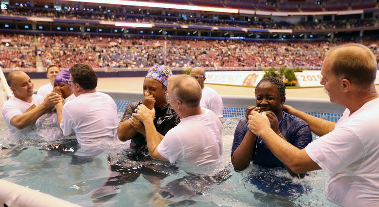 Three women wipe their faces after being batptized in a large swimming pool on the floor of the Dome at America’s Center in St. Louis on Saturday August 17, 2019 Three women wipe their faces after being batptized in a large swimming pool on the floor of the Dome at America’s Center in St. Louis on Saturday August 17, 2019