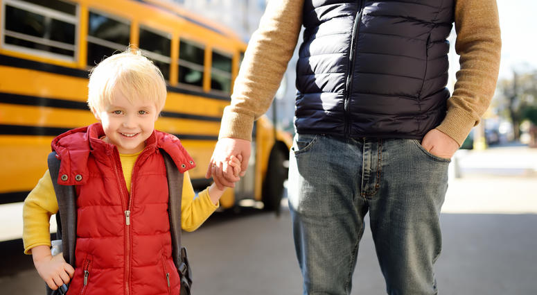 kid with father in front of school bus