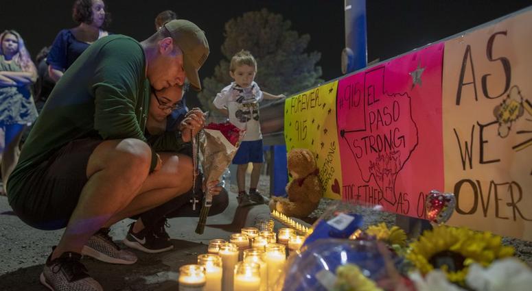 people mourn at a vigil after a shooting in an El Paso Walmart