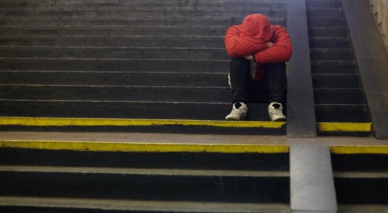 person sitting on stairs with head down