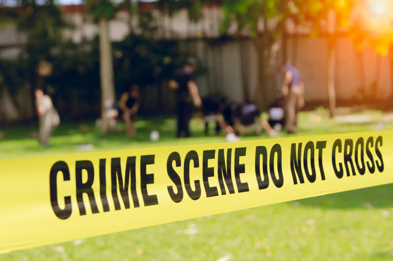 4 Muertos Y 11 Heridos En Tiroteo Durante Festival En California crime scene tape and blurred law enforcement team background