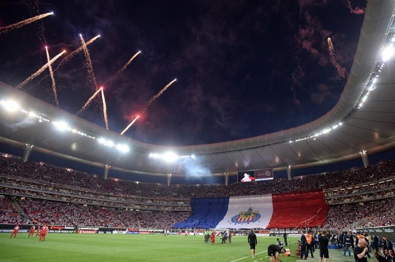 Un Hombre Tirado En Suelo Y Varios Aficionados Golpeados En El Clásico Chivas América. Fireworks go off before the game between the Chivas Guadalajara and the Toronto FC at Akron Stadium.