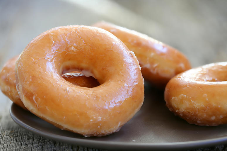 Docena De Donas A Un Dólar Por Aniversario De Krispy Kreme Glazed donuts background image. Macro with shallow dof.