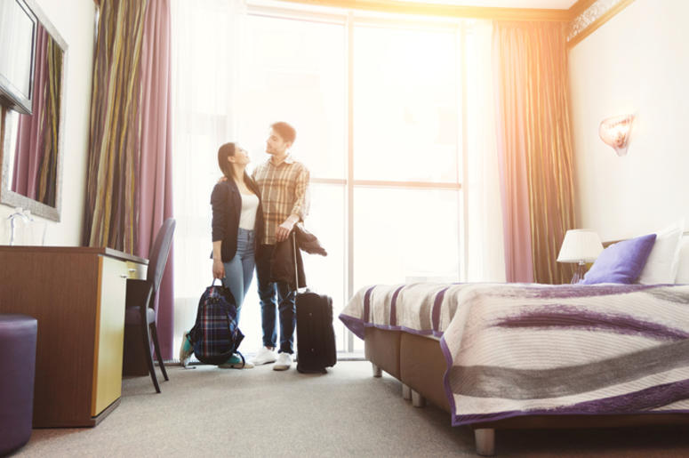 Young happy couple arrived to hotel room on honeymoon Young happy couple arrived to hotel room on honeymoon