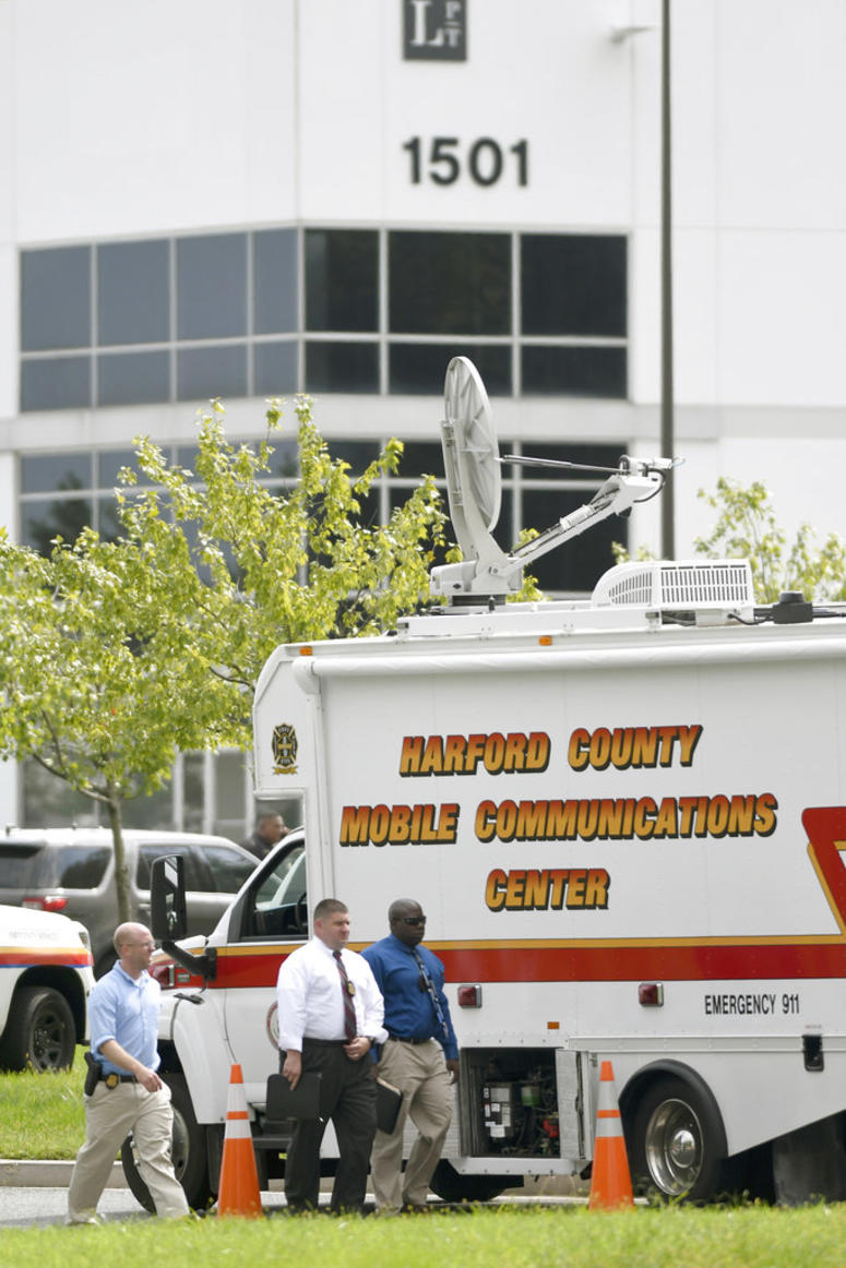 Law enforcement officials walk near the scene where a shooting took place in Aberdeen, Md