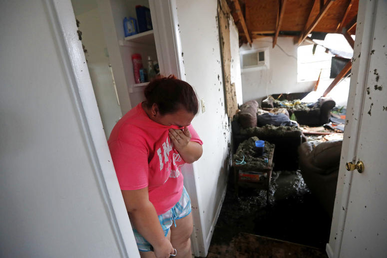 Kaylee O'Brian weeps inside her home after several trees fell on it during Hurricane Michael in Panama City