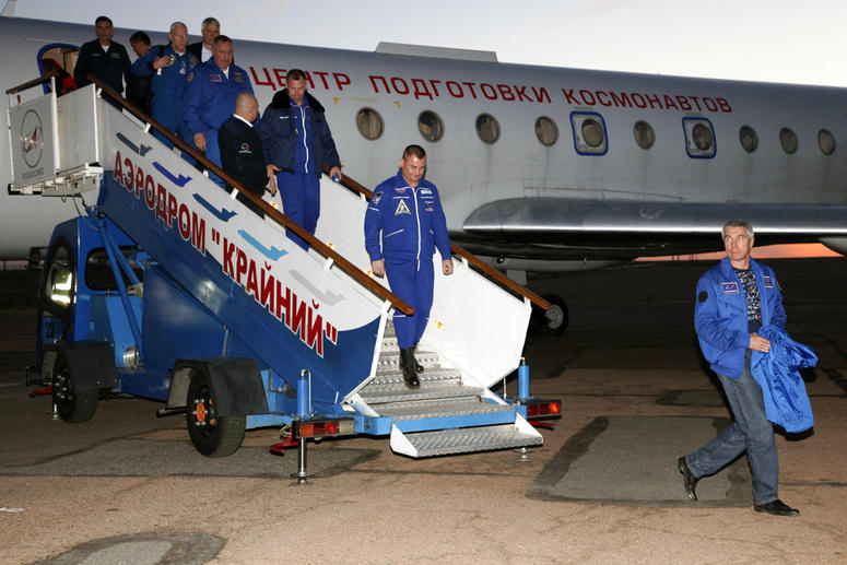 Russian cosmonaut Alexey Ovchinin, center, and U.S. astronaut Nick Hague, center left, arrive in Baikonur airport, Kazakhstan, after an emergency landing