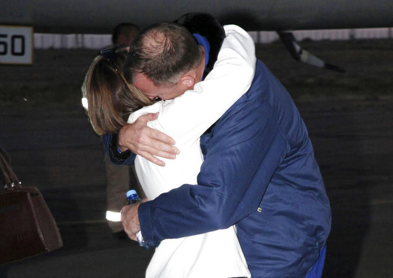 U.S. astronaut Nick Hague, right, embraces his wife Catie in Baikonur airport, Kazakhstan, after an emergency landing