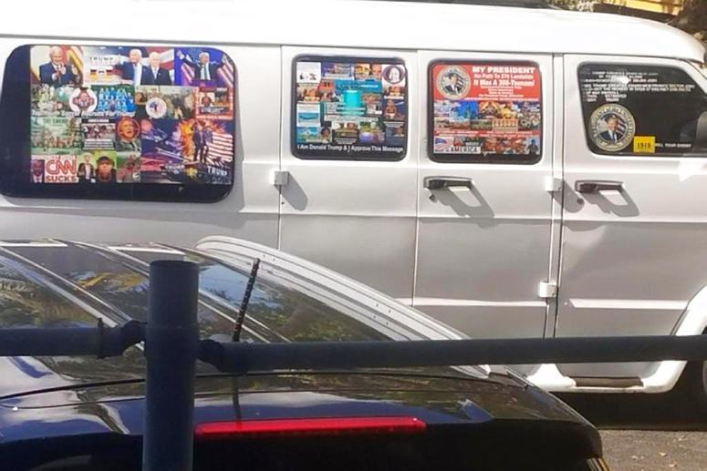 A van with windows covered with an assortment of stickers in Well, Fla.
