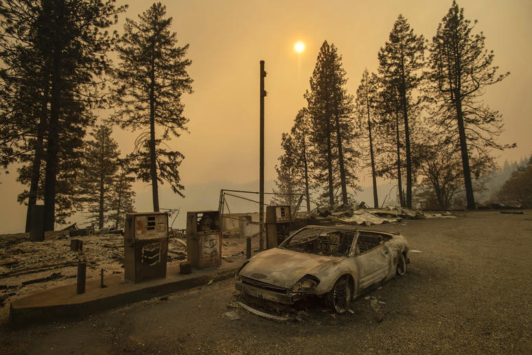 As the Camp Fire burns nearby, a scorched car rests by gas pumps near Pulga, Calif.