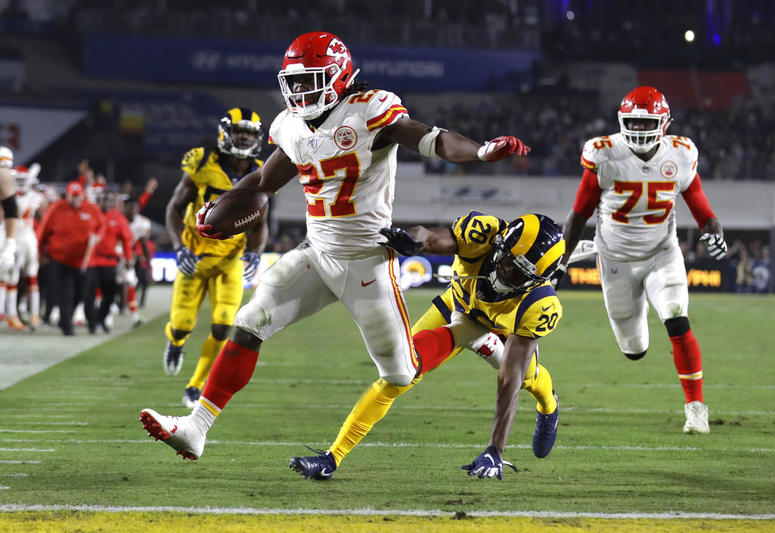 Kansas City Chiefs running back Kareem Hunt (27) scores a touchdown ahead of Los Angeles Rams free safety Lamarcus Joyner (20) as Chiefs offensive guard Cameron Erving (75) looks on during the first half