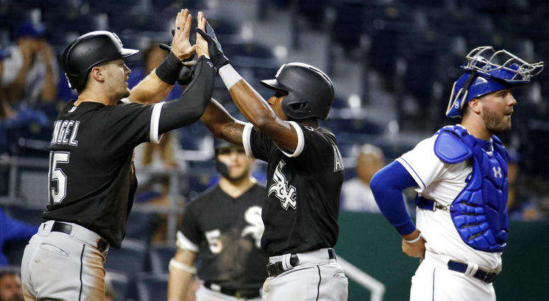 Chicago White Sox's Tim Anderson, center, celebrates with Adam Engel (15) as he crosses the plate past Kansas City Royals catcher Cam Gallagher after hitting a two-run home run during the 12th inning