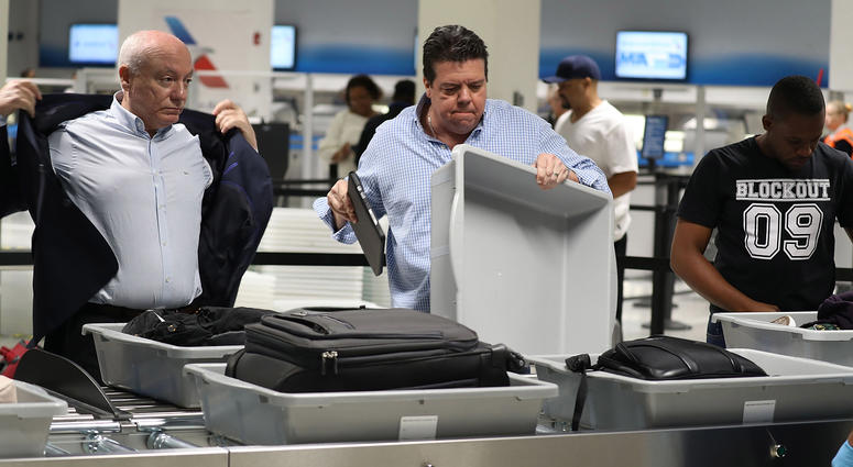 2 men at a TSA checkpoint at an airport