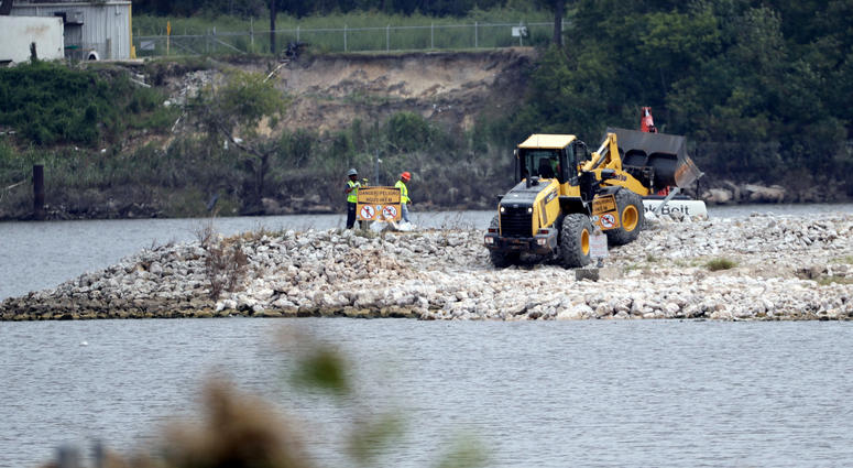 San Jacinto River Waste Pits In this Sept. 13, 2017, file photo, workers are shown at San Jacinto River Waste Pits near the Interstate 10 bridge over the river in Channelview, Texas. Federal environmental regulators have reached a long-awaited agreement with the owners of a polluted