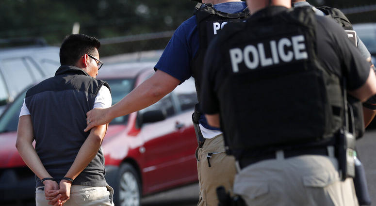 A man is taken into custody at a Koch Foods Inc. plant in Morton, Miss. A man is taken into custody at a Koch Foods Inc. plant in Morton, Miss.