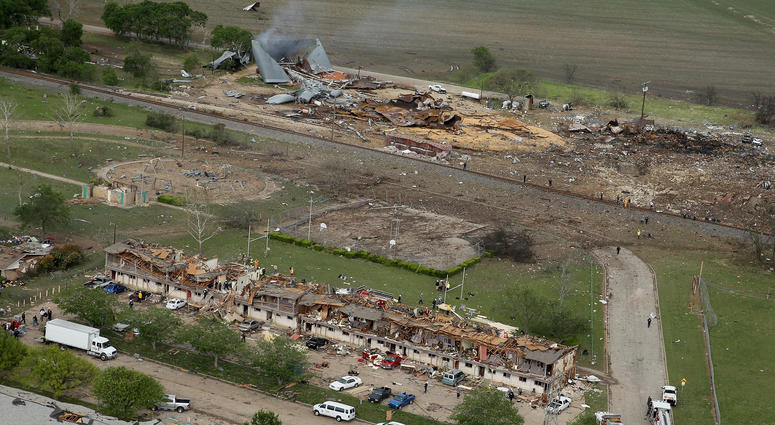 West, Texas File Photo: Search and rescue workers comb through what remains of a 50-unit apartment building (foreground) the day after an explosion at the West Fertilizer Company (background) destroyed the building April 18, 2013 in West, Texas. According to West May