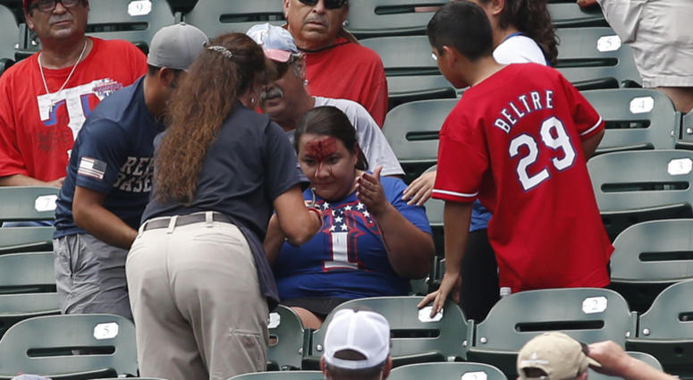 Rangers fans is attended to after being hit in the head with a ball Rangers fans is attended to after being hit in the head with a ball