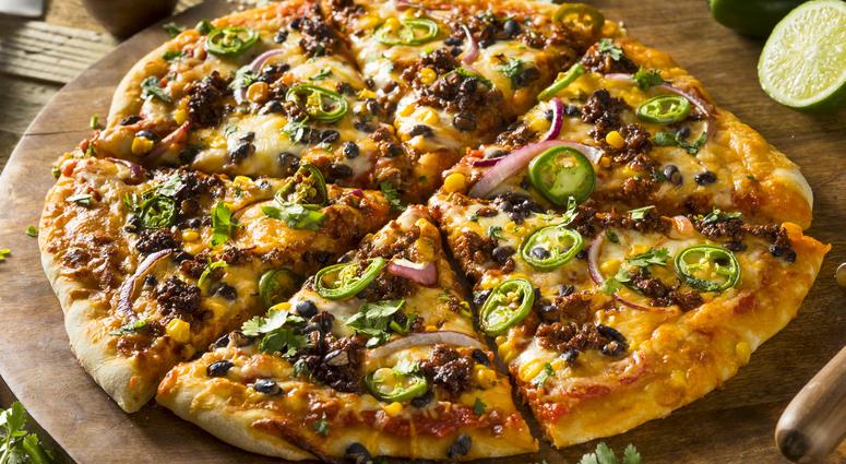 A whole pizza with sausage, olives and peppers