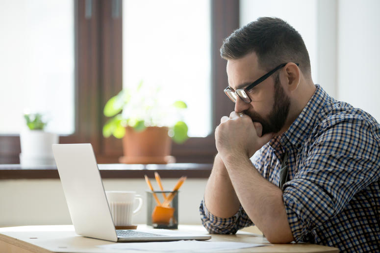 (fizkes/ iStock/ Getty Images Plus) Man looks contemplative about what he sees on computer screen