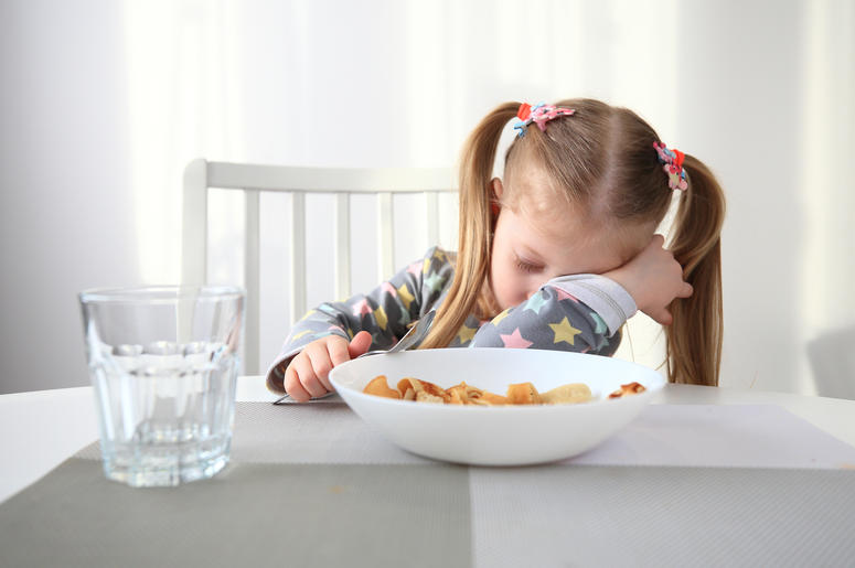 sleepy kid at breakfast