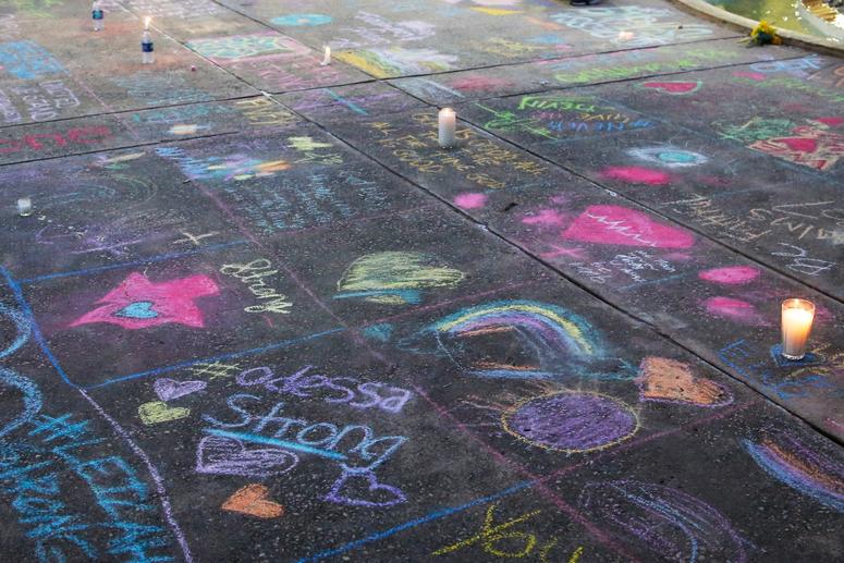 A sidewalk is filled with chalk messages following a prayer service, Sunday, Sept. 1, 2019, in Odessa, Texas, for the victims of a shooting spree the day before. Vigil for Odessa, Texas shooting