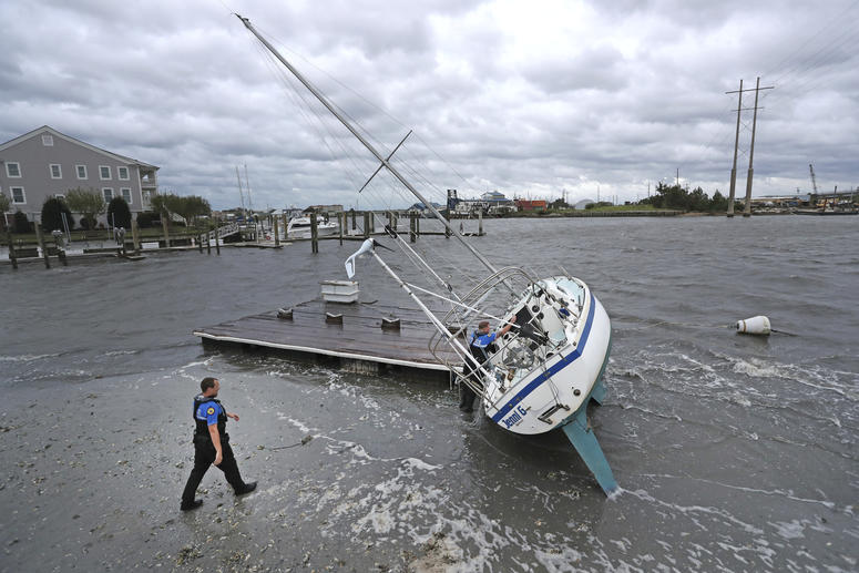 Beaufort Police Officer Curtis Resor, left, and Sgt. Micheal Stepehens check a sailboat for occupants in Beaufort, N.C. after Hurricane Dorian passed the North Carolina coast on Friday, Sept. 6, 2019. Hurricane Dorian passed the North Carolina