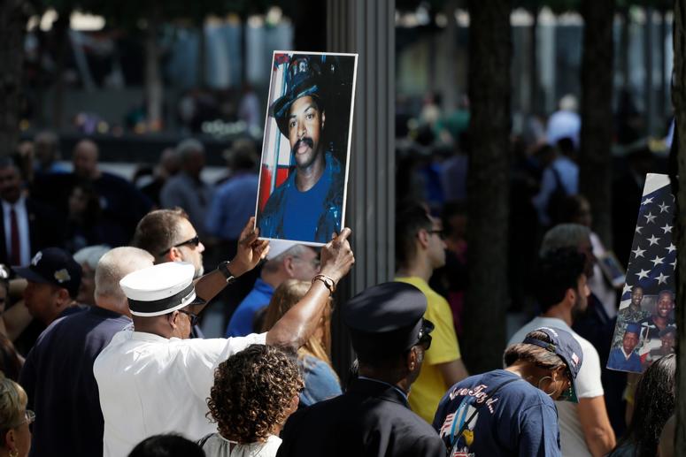 A photograph of fallen firefighter Leon Smith, Jr. is held up during a ceremony marking the 18th anniversary of the attacks of Sept. 11, 2001 at the National September 11 Memorial, Wednesday, Sept. 11, 2019 in New York. Anniversary of 9/11