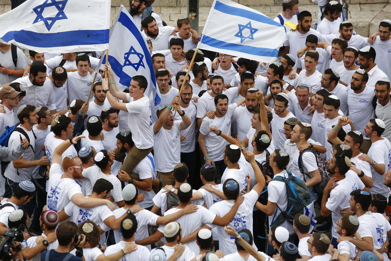 Israeli youths wave national flags outside the Old City's Damascus Gate. Israeli youths wave national flags outside the Old City's Damascus Gate.