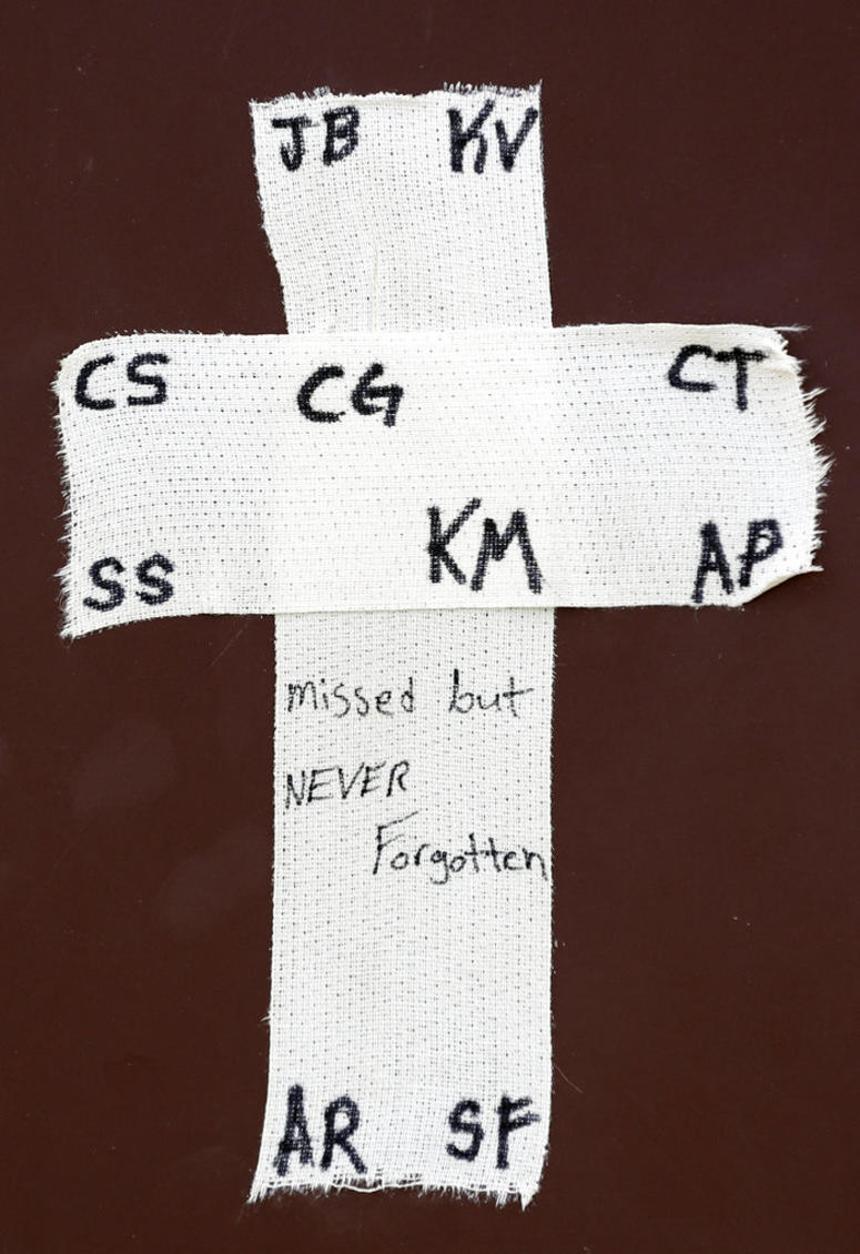 A tape cross with the initials of victims of the Santa Fe High School shooting is placed over the dugout of the Santa Fe baseball team before a baseball game against Kingwood Park High School. A tape cross with the initials of victims of the Santa Fe High School shooting is placed over the dugout of the Santa Fe baseball team before a baseball game against Kingwood Park High School.