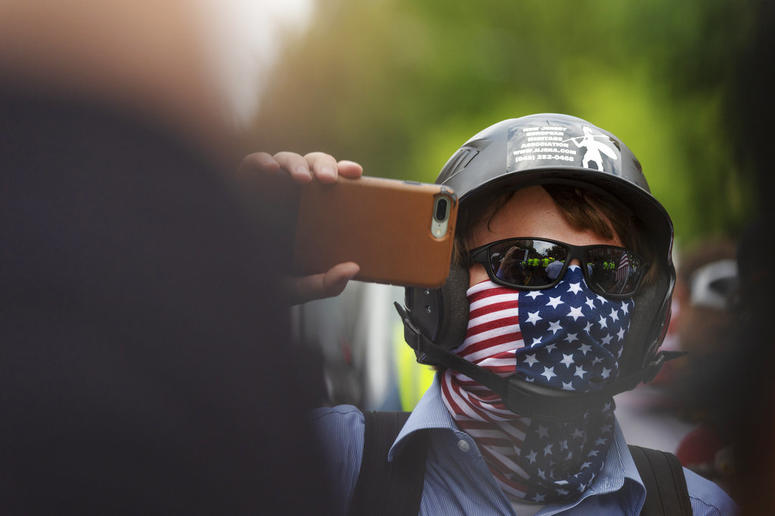 A white nationalist holds his phone while marching to Lafayette Square during the "Unite the Right 2" rally in Washington, Sunday, Aug. 12, 2018. A white nationalist holds his phone while marching to Lafayette Square during the "Unite the Right 2" rally in Washington, Sunday, Aug. 12, 2018.