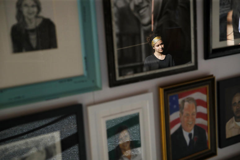 In this Sept. 25, 2018, photo, a woman looks at painted portraits of victims of the Oct. 1, 2017, mass shooting in Las Vegas on display at the Clark County Government Center in Las Vegas. In this Sept. 25, 2018, photo, a woman looks at painted portraits of victims of the Oct. 1, 2017, mass shooting in Las Vegas on display at the Clark County Government Center in Las Vegas.