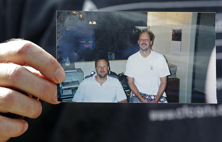 In this Oct. 2, 2017 file photo, Eric Paddock holds a photo of himself, at left, and his brother, Stephen Paddock, at right, outside his home in Orlando, Fla. In this Oct. 2, 2017 file photo, Eric Paddock holds a photo of himself, at left, and his brother, Stephen Paddock, at right, outside his home in Orlando, Fla.