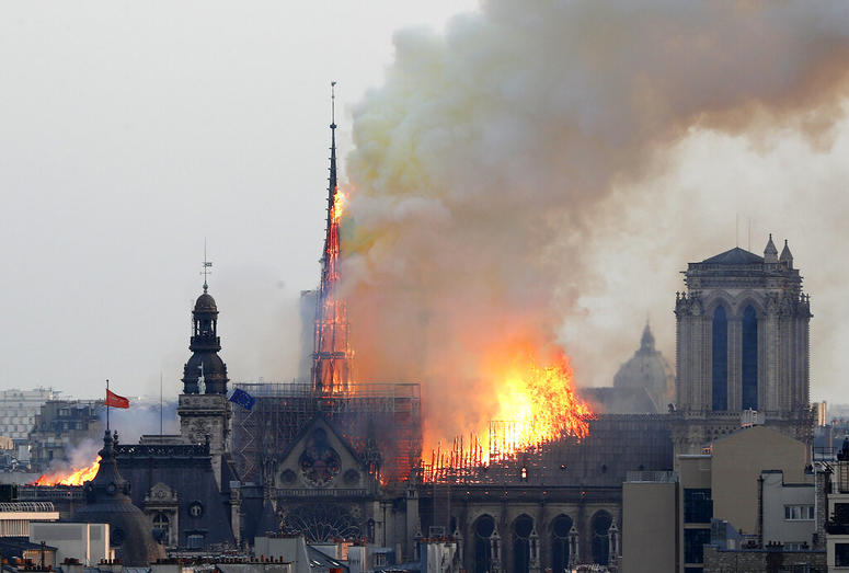 Flames rise from Notre Dame cathedral as it burns in Paris, April 15, 2019. Massive plumes of yellow brown smoke is filling the air above Notre Dame Cathedral and ash is falling on tourists and others around the island that marks the center of Paris. Notre Dame Cathedral fire