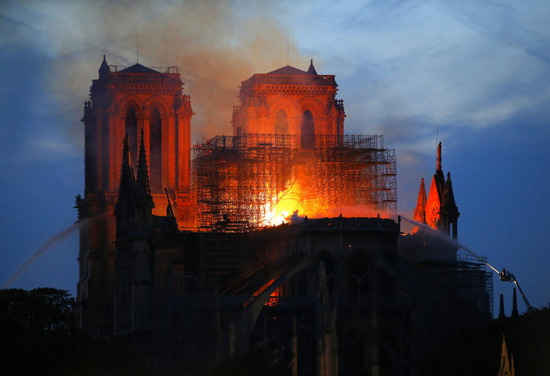 Firefighters tackle the blaze as flames and smoke rise from Notre Dame cathedral as it burns in Paris, Monday, April 15, 2019. Notre Dame Cathedral
