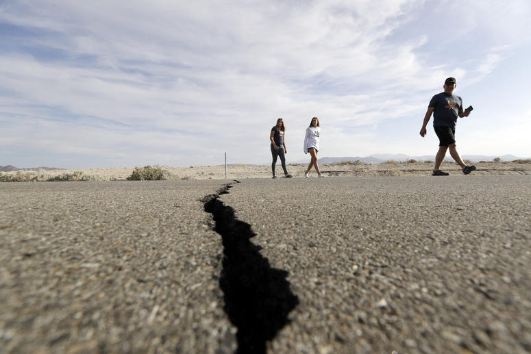 Visitors cross highway 178 next to a crack left on the road by an earthquake Sunday, July 7, 2019, near Ridgecrest, Calif. Visitors cross highway 178 next to a crack left on the road by an earthquake Sunday, July 7, 2019, near Ridgecrest, Calif.