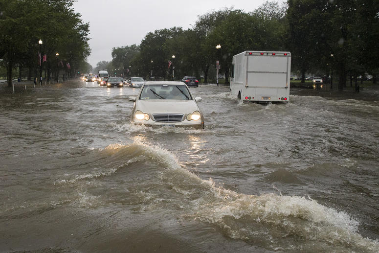 Heavy rainfall flooded the intersection of 15th Street and Constitution Ave., NW, stalling cars in the street, Monday, July 8, 2019, in Washington. Flooding
