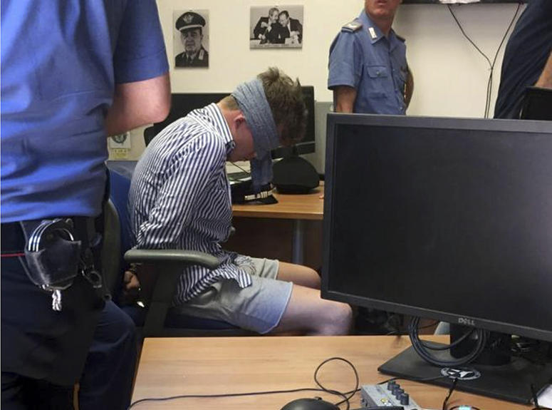 In this photo obtained from Italian Carabinieri, Gabriel Christian Natale-Hjorth sits blindfolded in a police station in Rome on Friday July 26, 2019. Gabriel Christian Natale-Hjorth