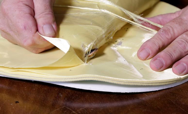 Steve Naremore, founder and CEO of TuffyPacks, disassembles one of his bulletproof panels to retrieve the nine flattened rounds that he fired from his Glock handgun, which were absorbed between the layers of the Aramid fiber ballistic material. Bullet-resistant backpacks