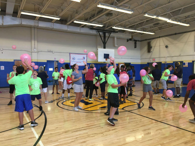 World–renowned tennis coach gives some pointers to kids at Police Athletic League.