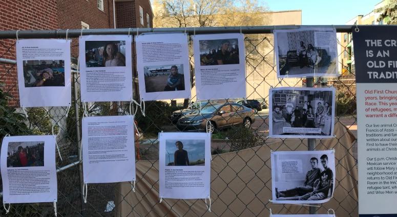 The refugee scene includes pictures and stories of real-life refugees hung on a fence nearby. The refugee scene includes pictures and stories of real-life refugees hung on a fence nearby.
