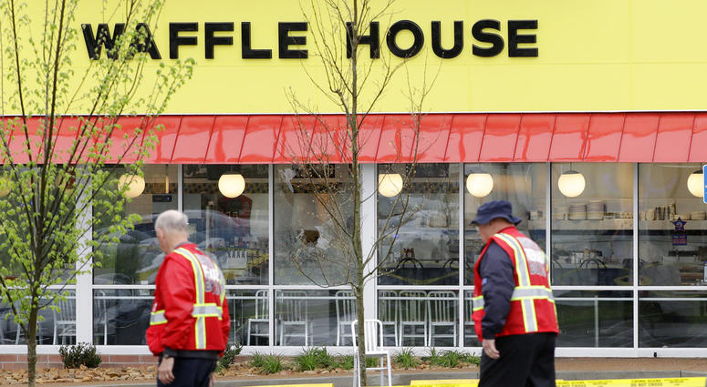 A police car sits in front of a Waffle House restaurant. A police car sits in front of a Waffle House restaurant.